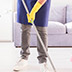 Person using a mop to clean a floor.