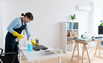 A person cleaning a desk in a modern room.